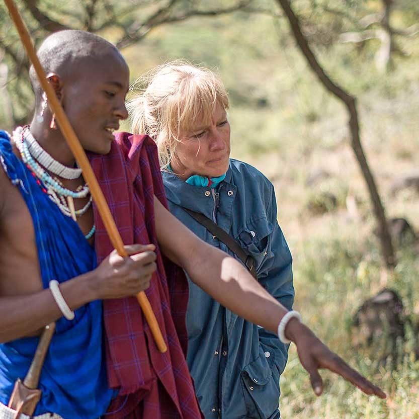 Lion Scout Kayanda pointing out recent tracks of lions to Ingela.