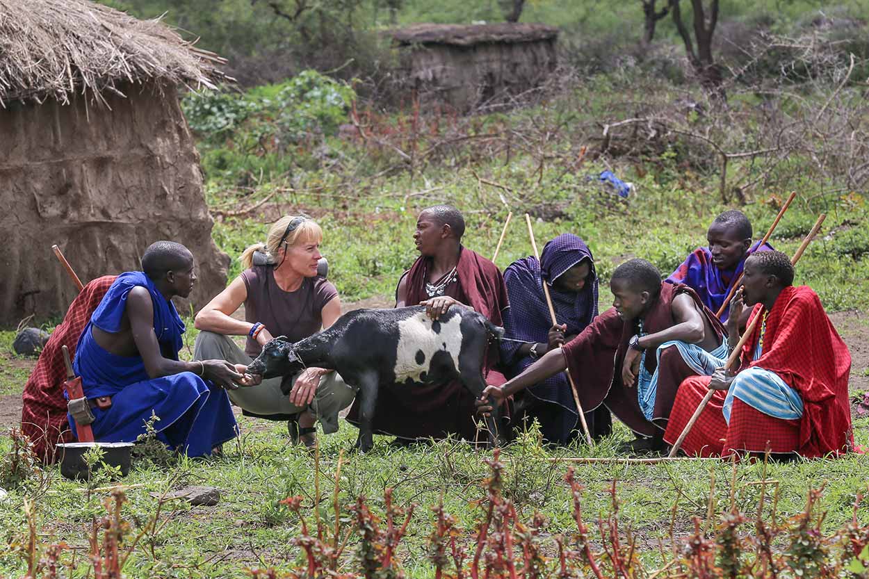 Ingela and lion scout Moloimet with other herders in Esere, discussing the latest event when striped hyena ripped into livestock enclosure (boma) and attacked goats.